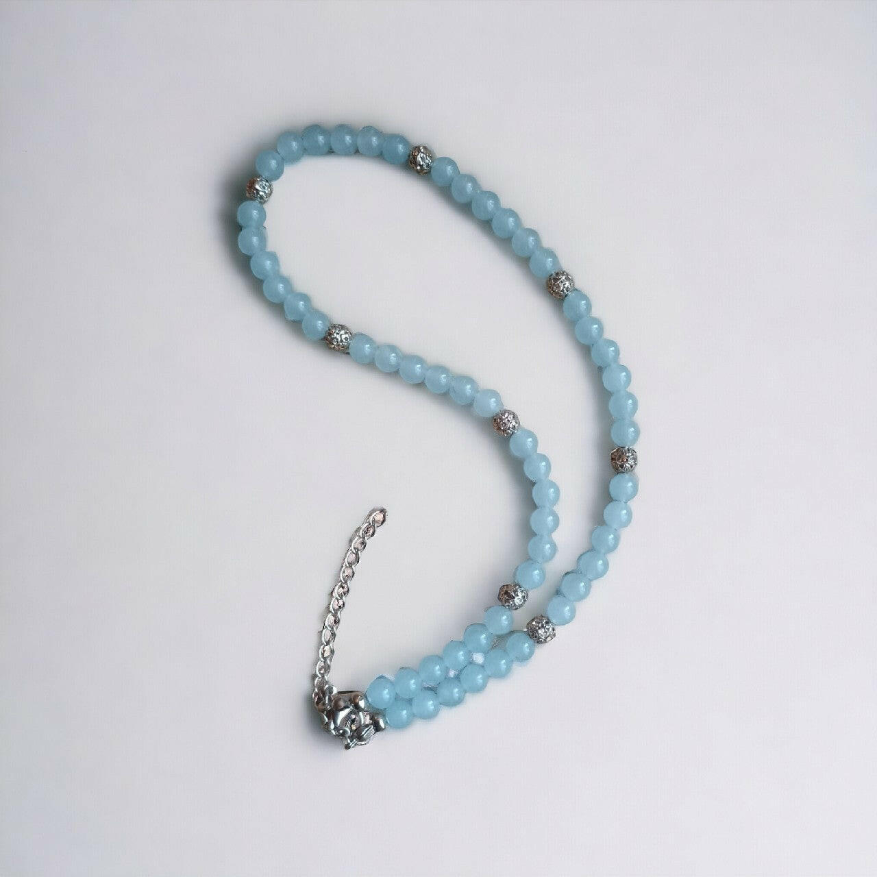 Subtelny naszyjnik handmade z gładkich, błękitnych koralików chalcedonu, urozmaicony błyszczącymi, metalowymi przekładkami. Posiada trwałe zapięcie i dodatkowy łańcuszek do dopasowania długości.