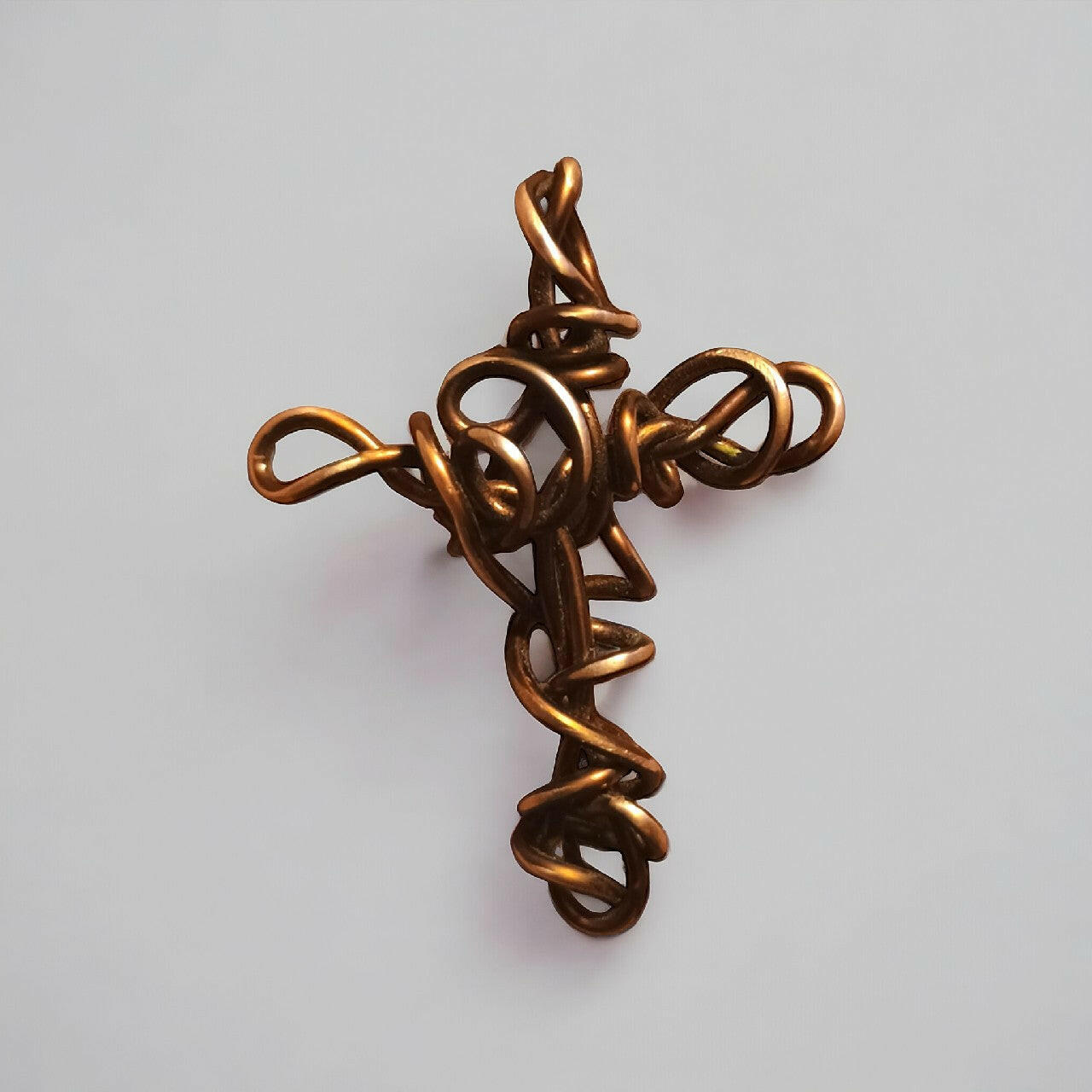Prosty, a zarazem wyrazisty wisiorek w formie krzyżyka z czystej miedzi, z charakterystycznym oplotem wire wrapping. Długość całkowita 6 cm.