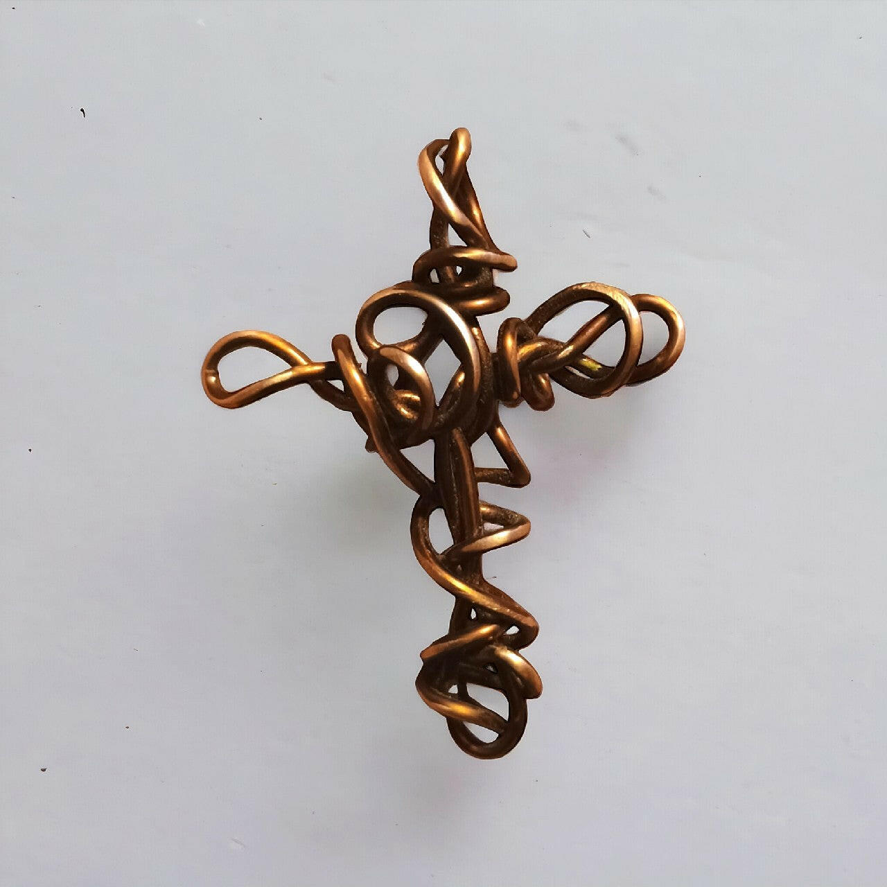 Wisiorek handmade w kształcie krzyża, wykonany z czystego miedzianego drutu techniką wire wrapping. Ciepły, miedziany odcień. Długość 6 cm.