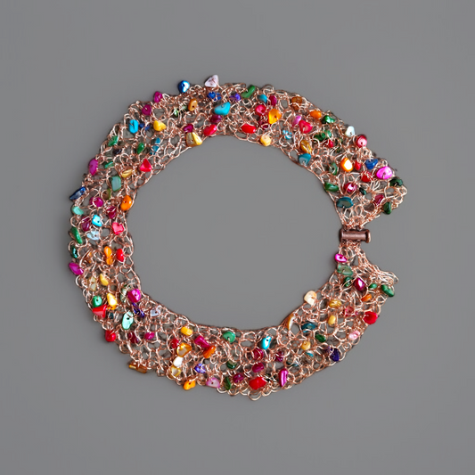 Naszyjnik w kształcie średniego okręgu z zapięciem wykonany na szydełku z miedzi i kolorowej masy perłowej