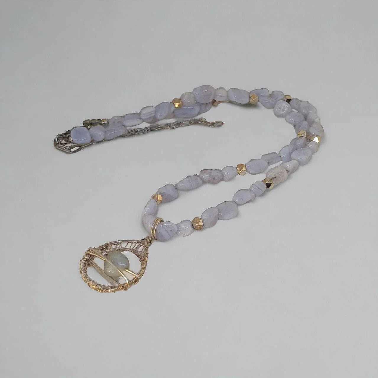 Naszyjnik handmade z naturalnych kamieni i miedzi, z fioletowymi koralikami i zawieszką.