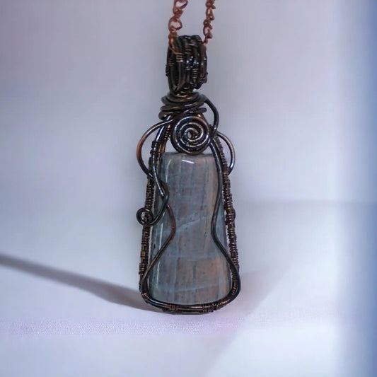 Misternie wykonany oplot z czystej miedzi, pokrytej oksydą dla uzyskania stylowej patyny, otula naturalny labradoryt w tym ręcznie robionym wisiorze