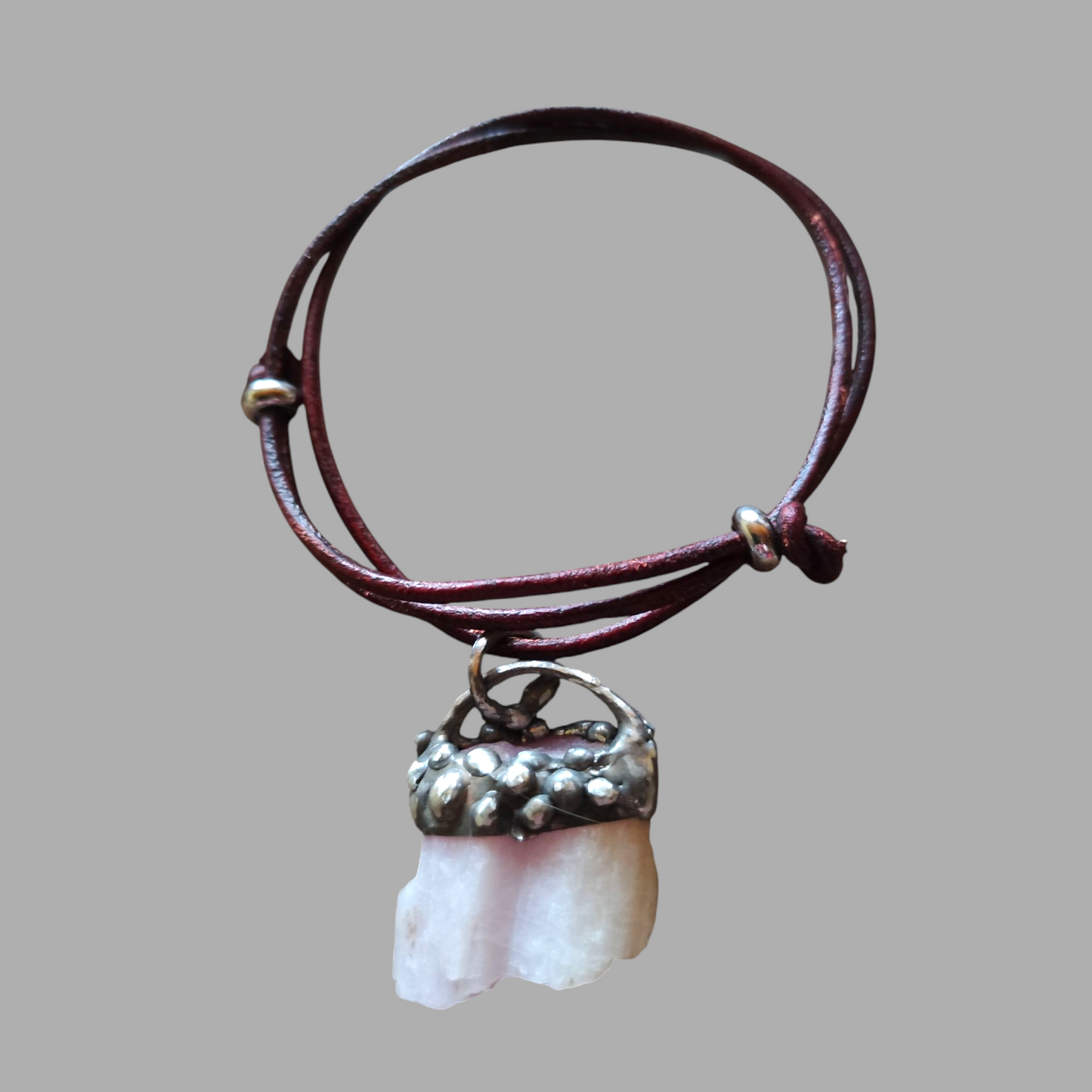 Ręcznie wykonany amulet spokoju. Liliowy kunzyt w surowej oprawie metodą Tiffany'ego na regulowanym rzemieniu.